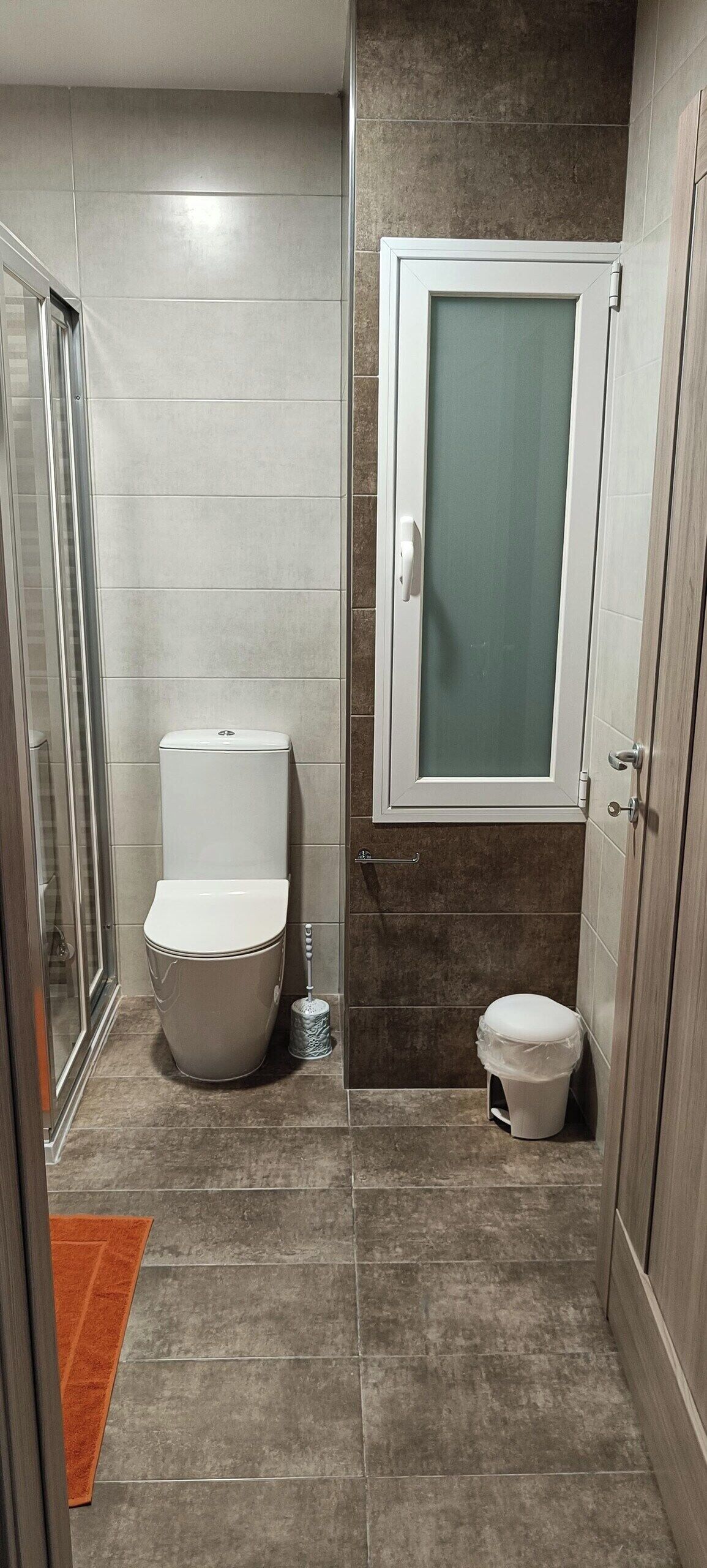 A bathroom with a toilet, a bidet, and a shower enclosure.