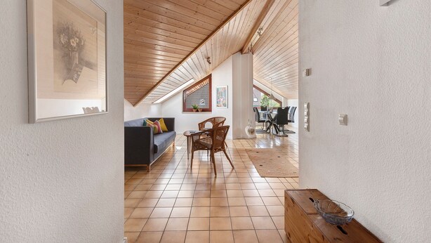 A spacious living area with a high ceiling, wooden beams, a sofa, a dining table, and a clear view to the outside. - Apartment Teckblick with Wi-Fi (Kirchheim unter Teck)