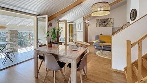 Un comedor amplio con una mesa y sillas de madera, un espejo grande y vistas al exterior.