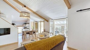 Un espacio habitable moderno con sofá, comedor y cocina.