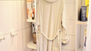 Um banheiro com pia, porta-toalhas com toalha e produtos de higiene em prateleiras.