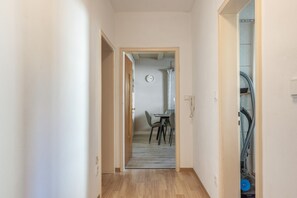 A hallway with a dining area at the end, featuring a clock on the wall. - Apartment 'Seus' with Wi-Fi (Dorfprozelten)