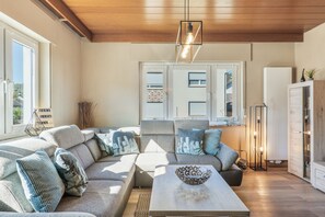 A modern living room with a sectional sofa, a coffee table, and a decorative bowl.
