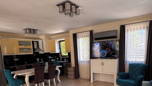 A spacious living area with a dining table, chairs, sofas, and a kitchen in the background. - Villa Turaman Dalyan: Large 4-Bedroom House, Pool, Jacuzzi, Garden. Sleeps 10 (Muğla)