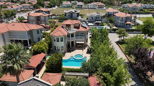 Un quartier résidentiel comprenant plusieurs maisons, une piscine et une pelouse bien entretenue.