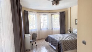 A hotel room with a bed, a desk, and a chair. - Villa Turaman Dalyan: Large 4-Bedroom House, Pool, Jacuzzi, Garden. Sleeps 10 (Muğla)
