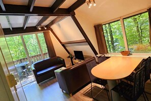 A modern interior with a dining table, chairs, a sofa, and a television. - Charming chalet in Durby with patio (Durbuy)