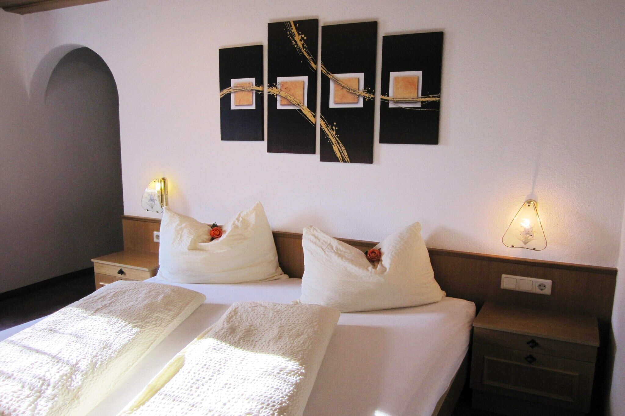 Hotelkamer met een bed, twee nachtkastjes, een kunstwerk aan de muur en een nachtkastje met een lamp.
