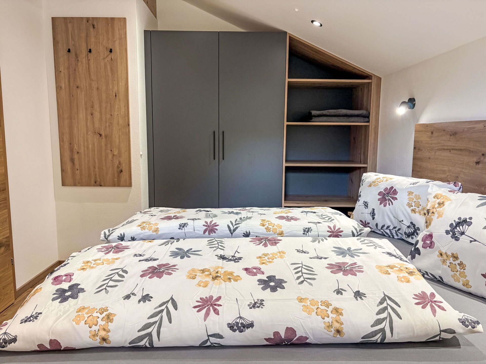 Une chambre à coucher comprenant un lit, une armoire et une étagère intégrée.
