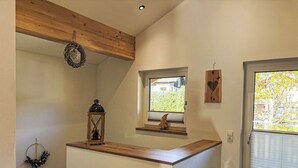 Una cocina moderna con encimera de madera, una ventana con vistas y una puerta con panel de vidrio.