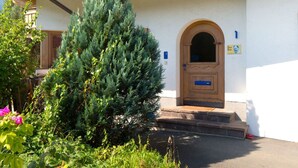 Ein Gebäude mit einer Holztür und Stufen, die zu einer Veranda führen.