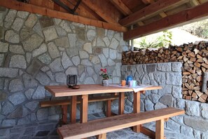 A stone wall with a wooden bench and picnic table.
