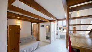 Una habitación con cama, techo de madera y vistas por la ventana.