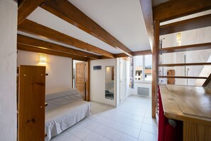 A room with a bed, a wooden ceiling, and a view through a window. - Cozy Apartment Place Paoli – Mountain View, Heart of Corte (Corte)