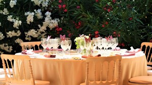 A round table set with white tablecloth, glassware, and pink napkins, surrounded by wooden chairs. - Room 'Suite Presidencial' with Shared Terrace, Wi-Fi and Air Conditioning (Guadarrama)