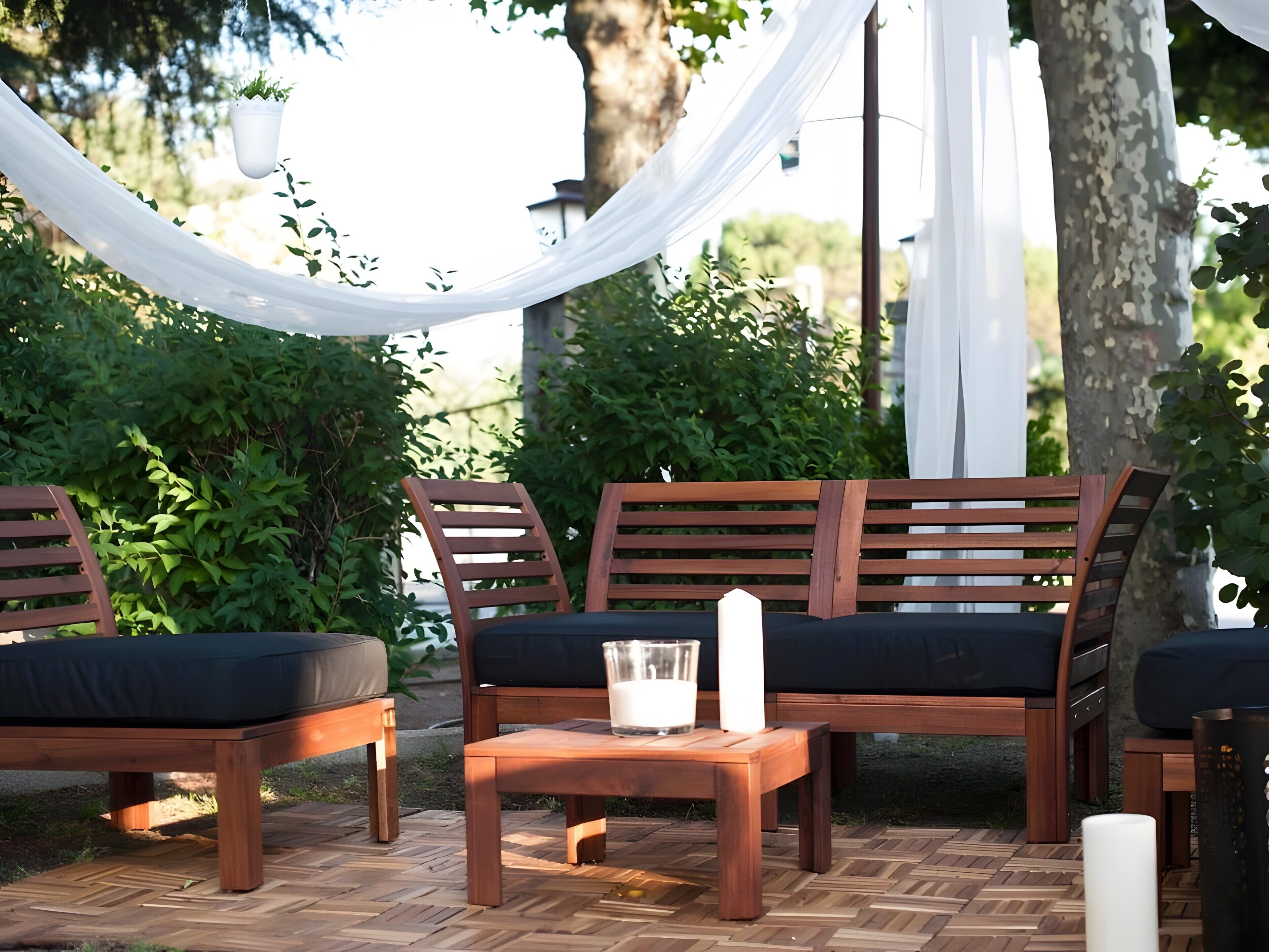 Un área de estar al aire libre con muebles de madera y un toldo blanco.