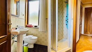 Ein Badezimmer mit Waschbecken, Toilette, Dusche und einem Fenster.
