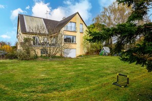 Ein zweistöckiges Haus mit Satteldach, einer sichtbaren Garage und einem Rasen mit einem Fußballtor.