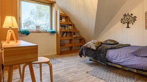 A bedroom with a bed, a desk, a chair, a bookshelf, and a window. - Holiday Home "Villa for 8 Guests – Porte du Ried" with Mountain View, Private Terrace & Wi-Fi (porte du ried)