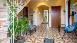 A staircase with a metal railing, a bench, a blue chair, and a door labeled 'PRIVE.' - Holiday Home "Villa for 8 Guests – Porte du Ried" with Mountain View, Private Terrace & Wi-Fi (porte du ried)