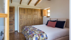 Une chambre à coucher avec un lit, une armoire en bois et une fenêtre.
