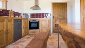 Une cuisine avec des meubles de rangement en bois, un lave-vaisselle, un four et un banc en bois.