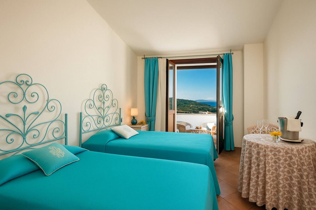 Habitación de hotel con dos camas, un balcón, una mesita con hervidor y vista al mar.