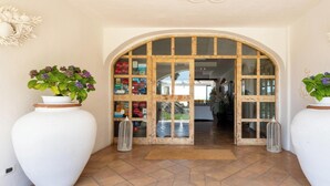 Un arco de entrada que da a una habitación con suelo de baldosas y una planta en maceta a la izquierda.
