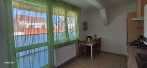 Eine kleine Küche mit Esstisch und Stühlen, einem Heizkörper und einem Herd.