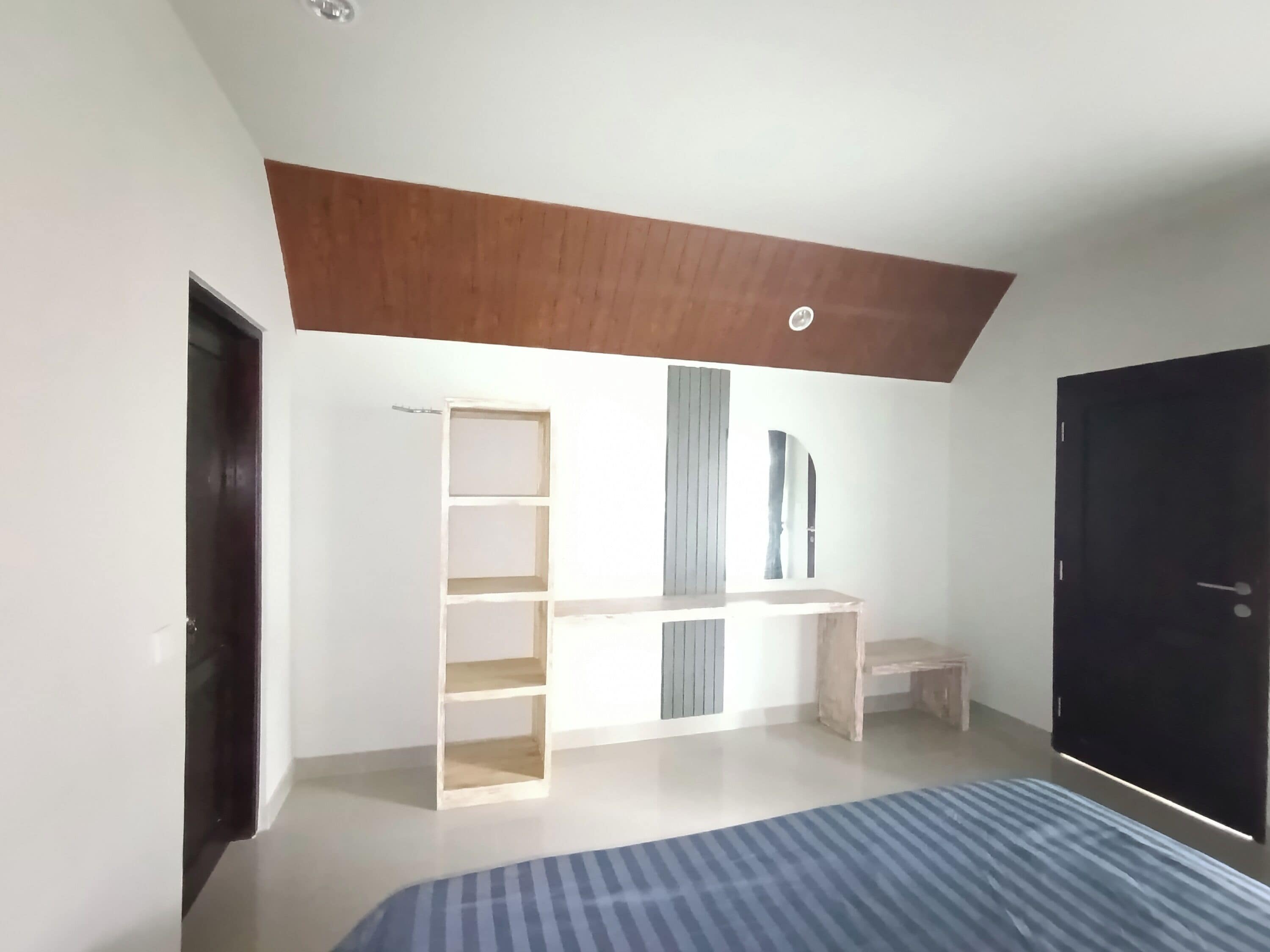 Une chambre à coucher avec un lit, une armoire, un bureau et une porte.