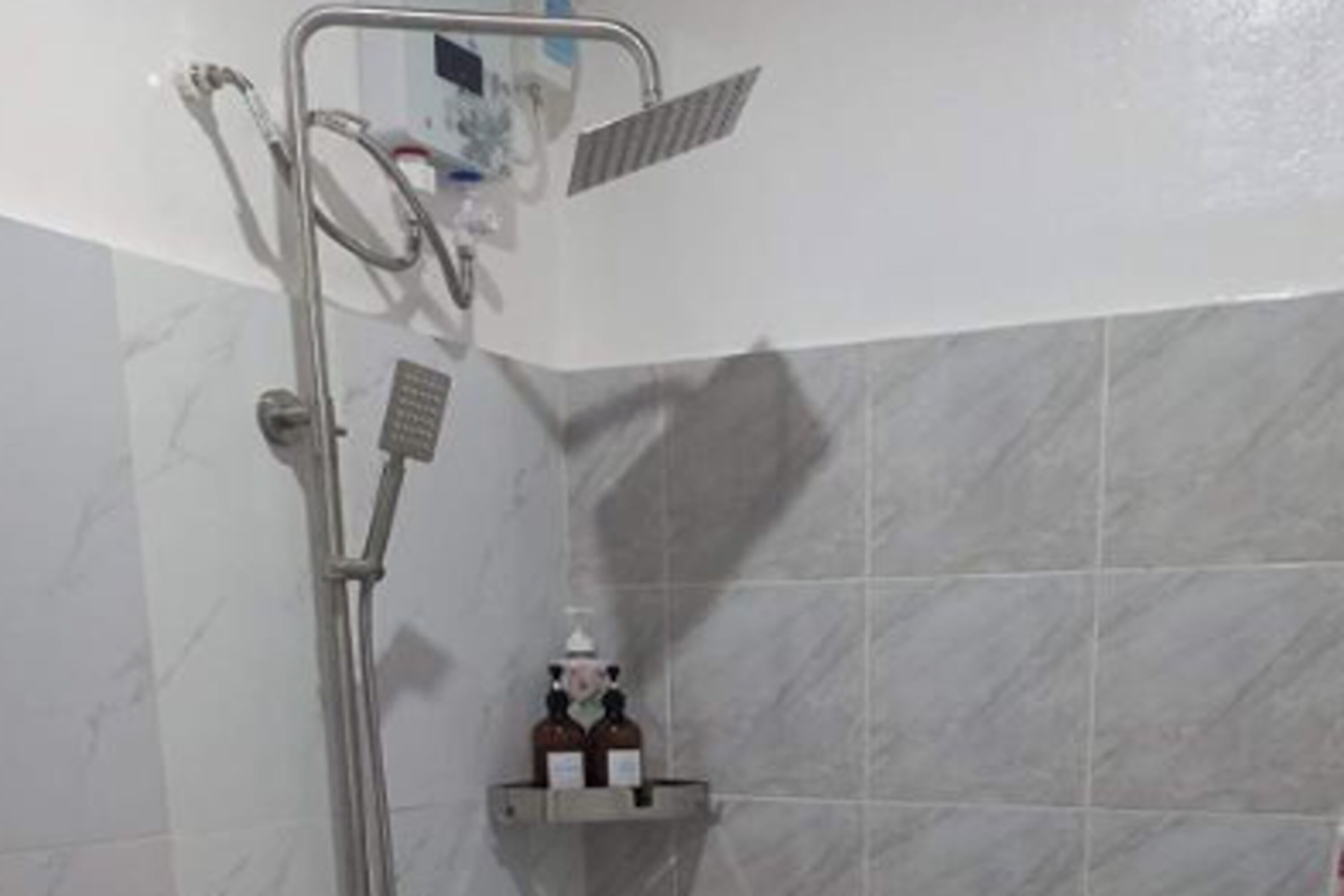 A bathroom with a shower, a towel rack, and a shelf with toiletries.
