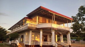 A two-story house with a balcony, columns, and a covered porch. - Seven Waves Beachfront (Bauang)