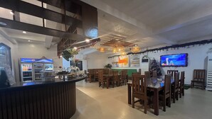 Un interior de restaurante con una barra, mesas de madera y sillas.