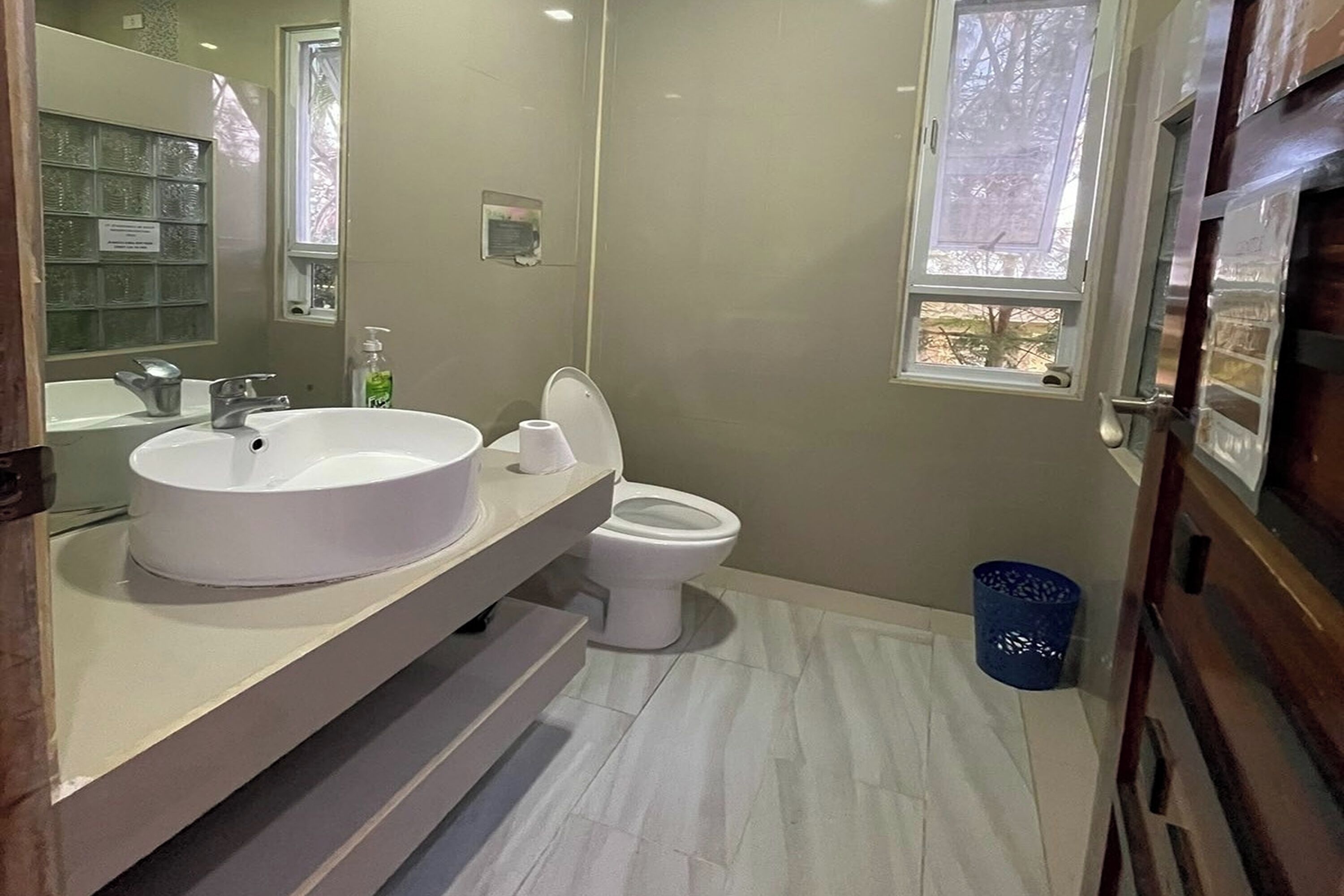 Ein Badezimmer mit Waschbecken, Toilette und einem Fenster.