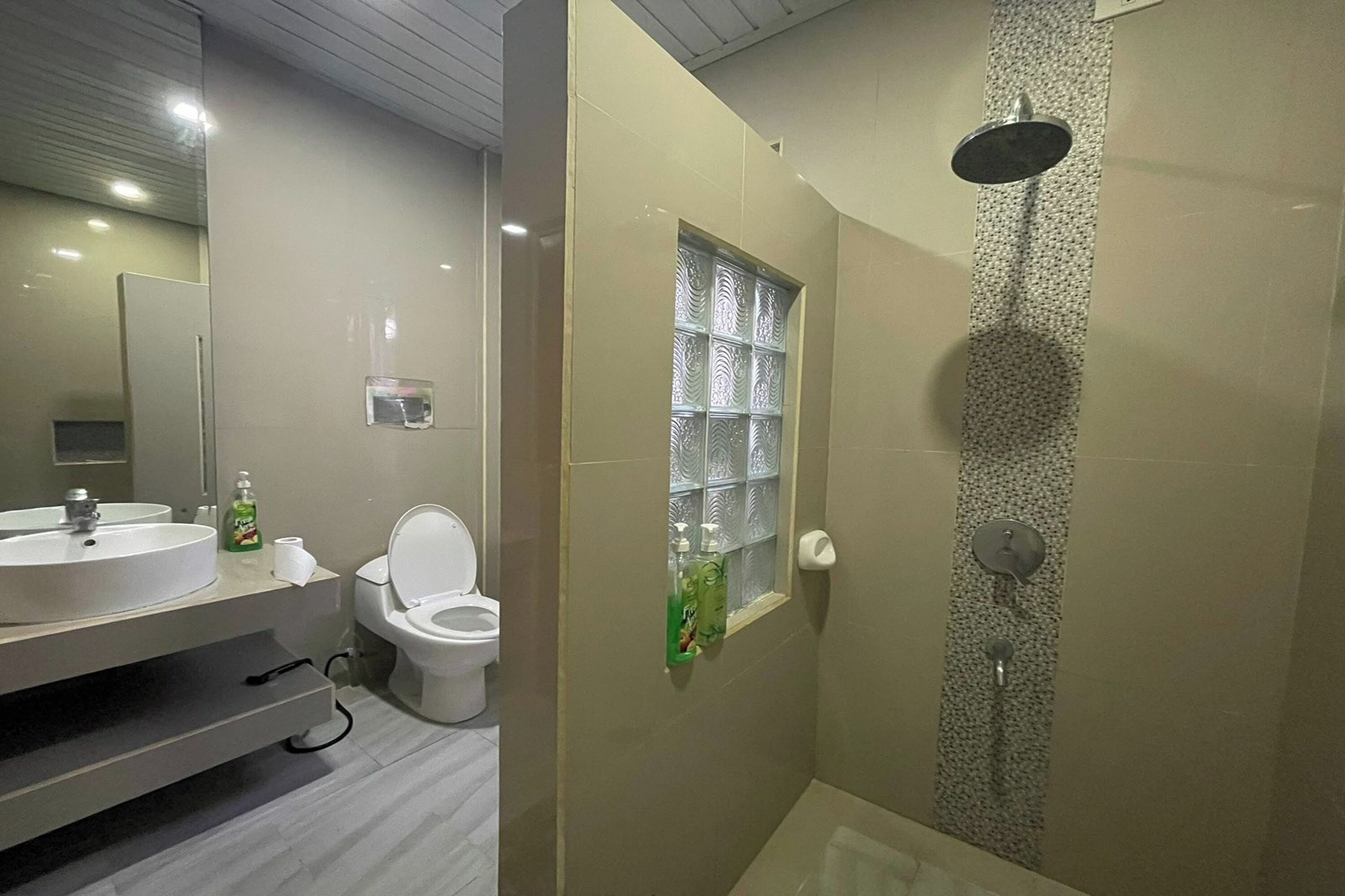 Un baño moderno con inodoro, lavabo y ducha.