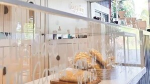 Una cocina moderna con una vitrina de vidrio, tablas de cortar de madera y una encimera blanca.