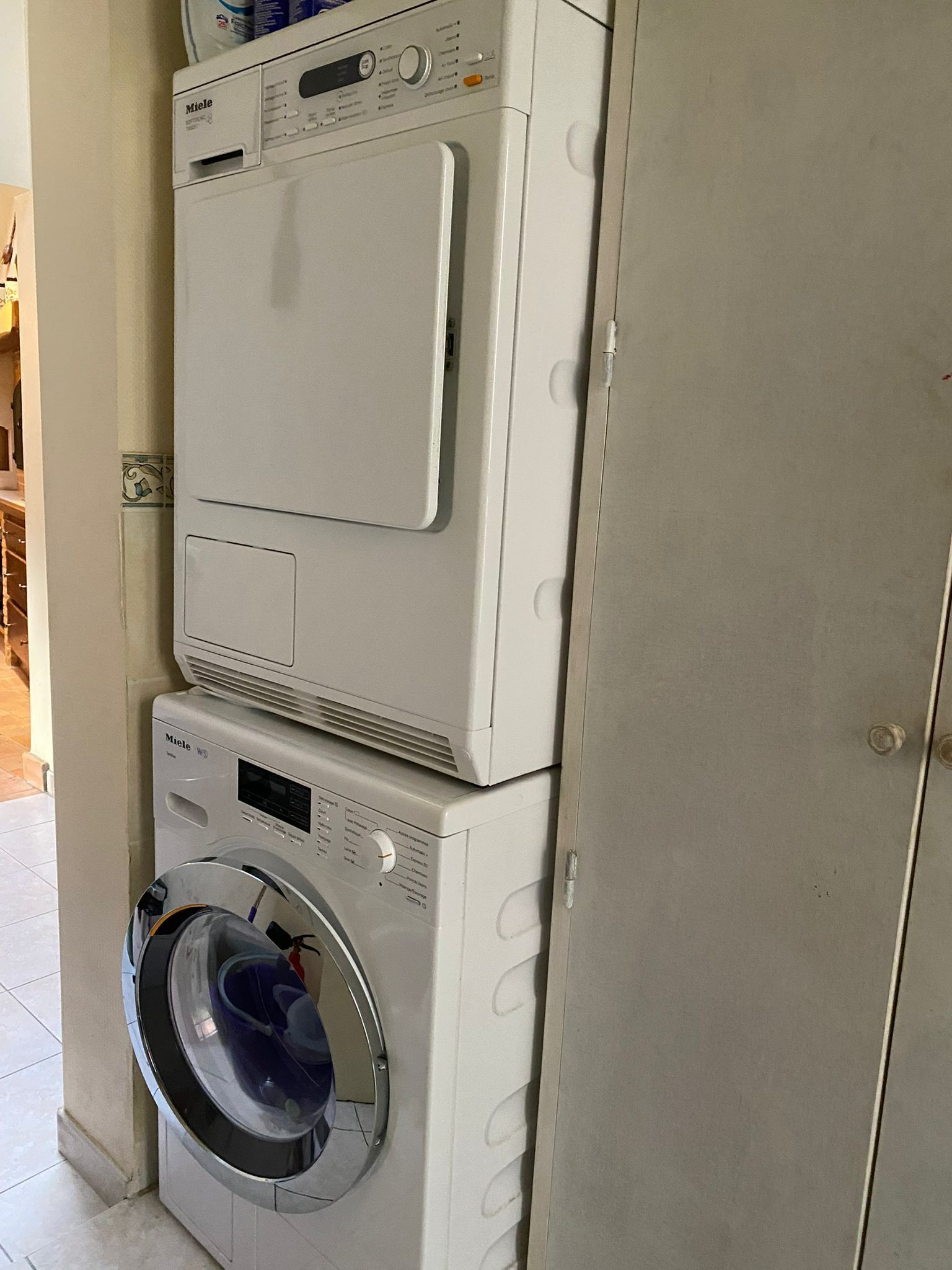 A stacked washer and dryer unit with a control panel and a door.