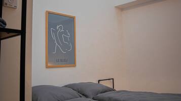 Een slaapkamer met een stapelbed, dakraam en een gekaderd kunstwerk aan de muur.