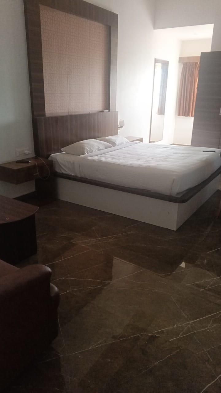 Ein Schlafzimmer mit einem großen Bett, einem Nachttisch, einem Holzstuhl und einem Kleiderschrank.