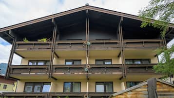 Un immeuble à plusieurs étages doté de balcons, de rampes en bois et d’une colonne centrale.
