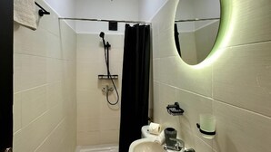 Un baño pequeño con inodoro, lavamanos y ducha.