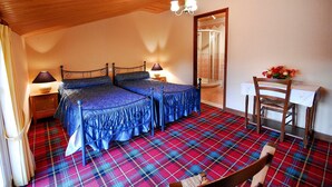 A bedroom with two beds, a wooden ceiling, a mirror, a table with a chair, and a plaid carpet. - Bed and Breakfast 'Chambre Mansardée' with Shared Terrace, Shared Garden and Wi-Fi (VERRIERES)