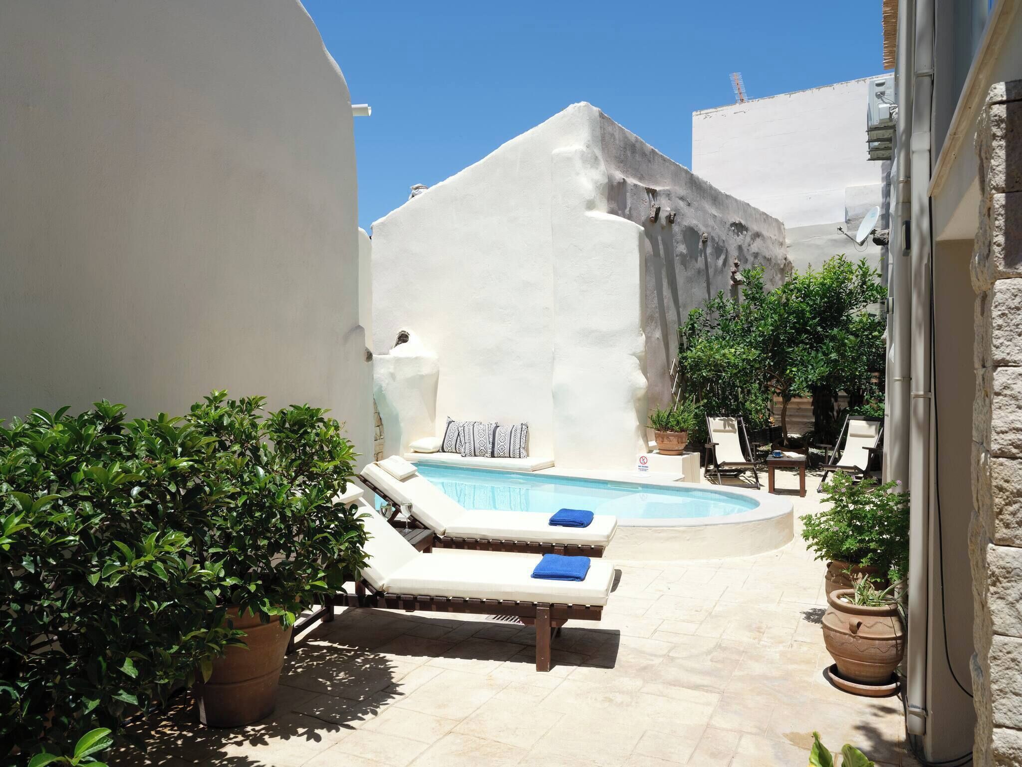 A pool area with lounge chairs and a small hot tub.