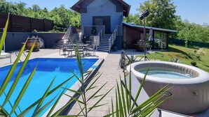 A pool area with a hot tub, a staircase leading to a building, and outdoor seating. - Gorgeous home in Slavonski Brod with sauna (Slavonski Brod)