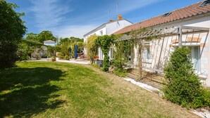 A residential property with a garden, a pergola, and a white building with a tiled roof. - Guest Room “Ré” – Bright, Relaxing Space for Two (Virson)