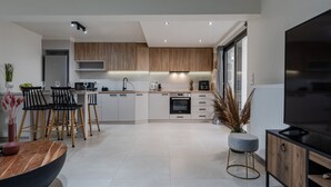 A modern kitchen with a central island, wooden cabinets, and a built-in oven. - Stone Project 2 a cozy retreat with private Pool (Pigi)