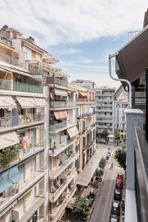 Un edificio residenziale a più piani con balconi, posti a sedere all'aperto e vista sulla strada.