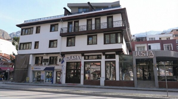 A multi-story building with a storefront named 'JUSTA CHEF' and another named 'JUSTA.' - 1921Justa otel (Amasya)