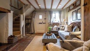 A cozy living room with a staircase, a sofa set, and a wooden ceiling. - Two Cottages near Stratford-upon-Avon (Clifford Chambers)