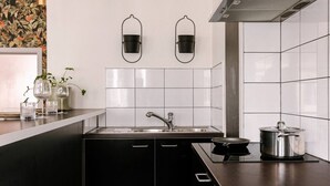 Een moderne keuken met een zwart aanrecht, een roestvrijstalen spoelbak en een pan op het fornuis.